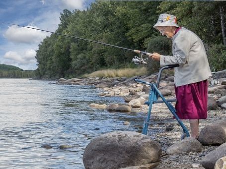 Woman fishing by the river with mobility walker